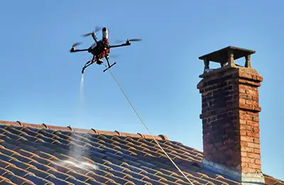 Un drone projetant de l’eau sur un toit.