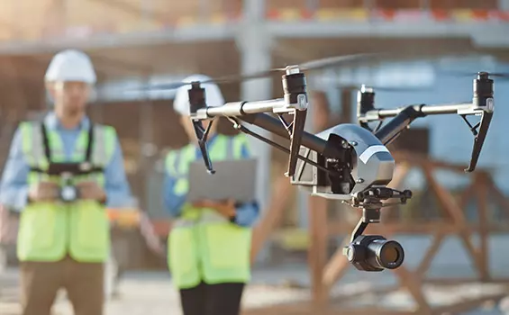 Un groupe d’ouvriers du bâtiment avec un drone devant eux.