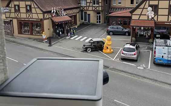 Vue d'une rue avec des voitures garées devant un immeuble filmé par un timelapse